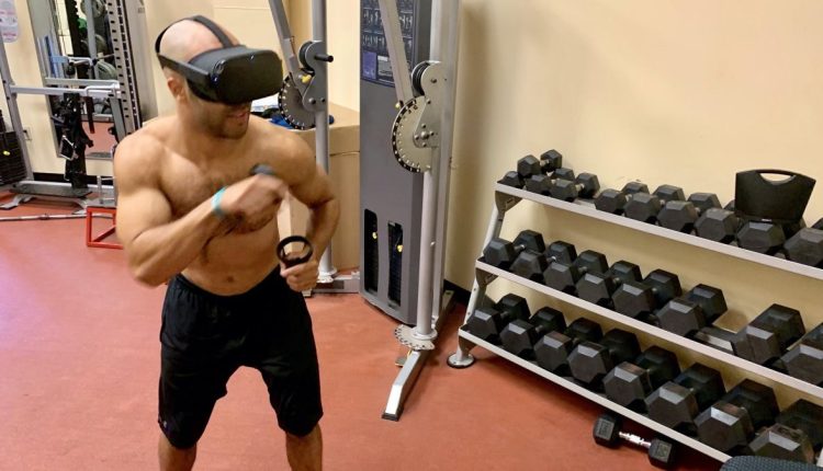 A man shadow boxes while wearing an Oculus Quest headset
